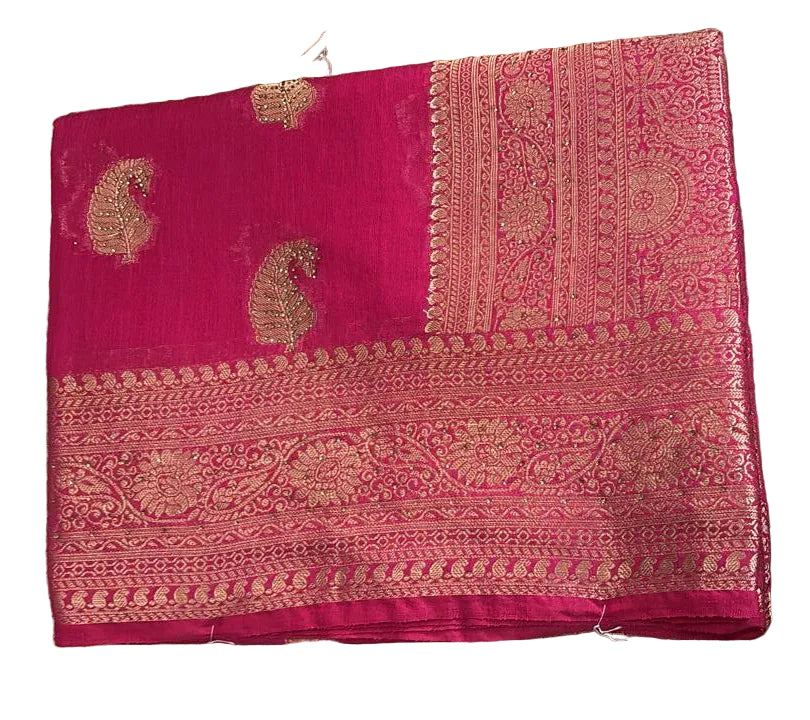 Pink saree with gold patterns on a textured surface
