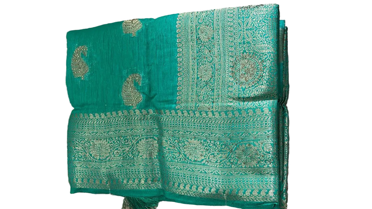 Teal fabric with intricate patterns on a textured surface